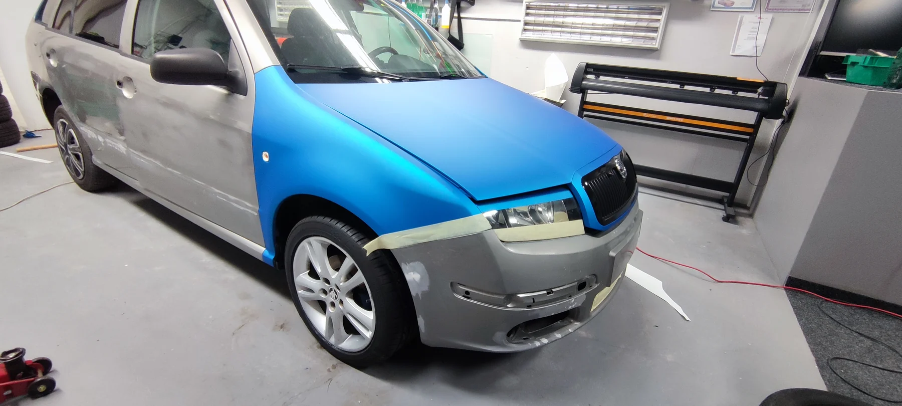 Fabia kombi během proměny se světlým původním bokem a modrou kapotou