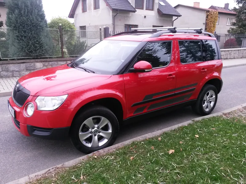 Červená Škoda Yeti s černými bočními pruhy zepředu a z boku