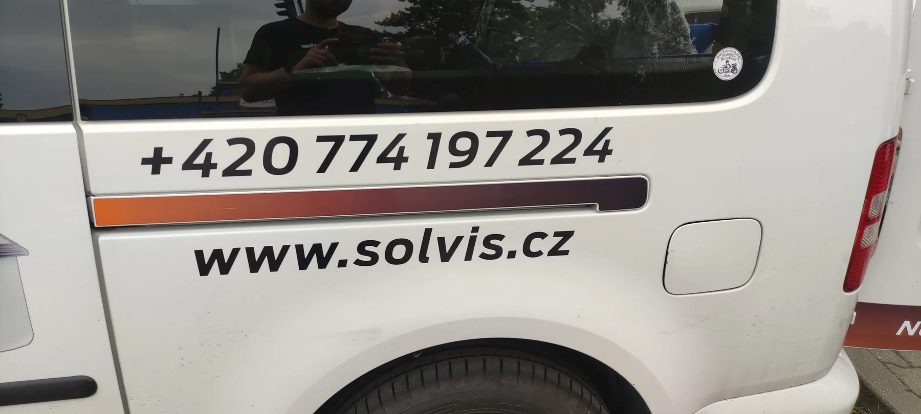 Kontaktní údaje a oranžová linka na zadním boku Caddy SOLVIS