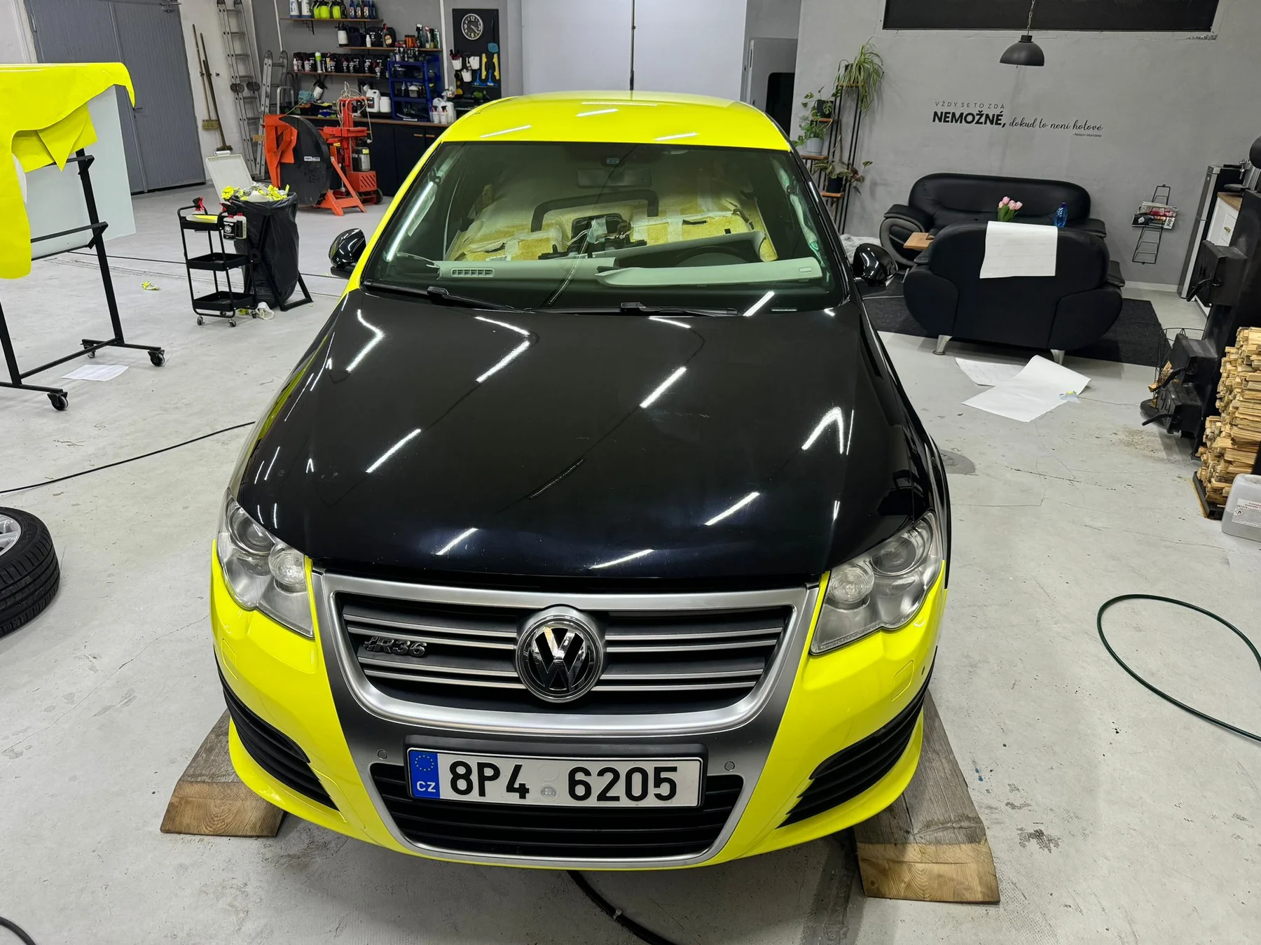 Volkswagen Passat během proměny do žluté s ještě černou kapotou