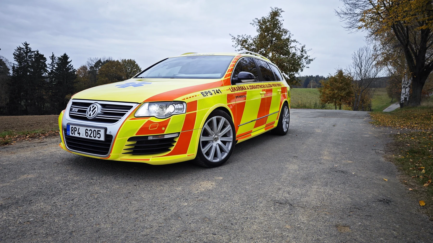 Žlutooranžový Volkswagen Passat EPS Medical zepředu na silnici