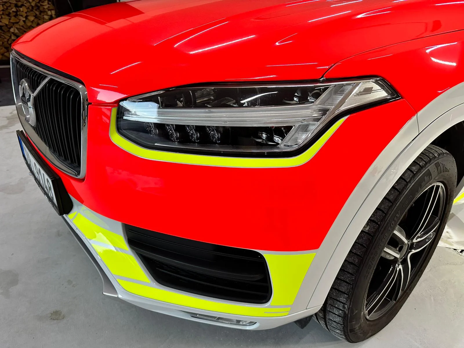 Detail žluté grafiky kolem předního světla Volva XC90 záchranné služby