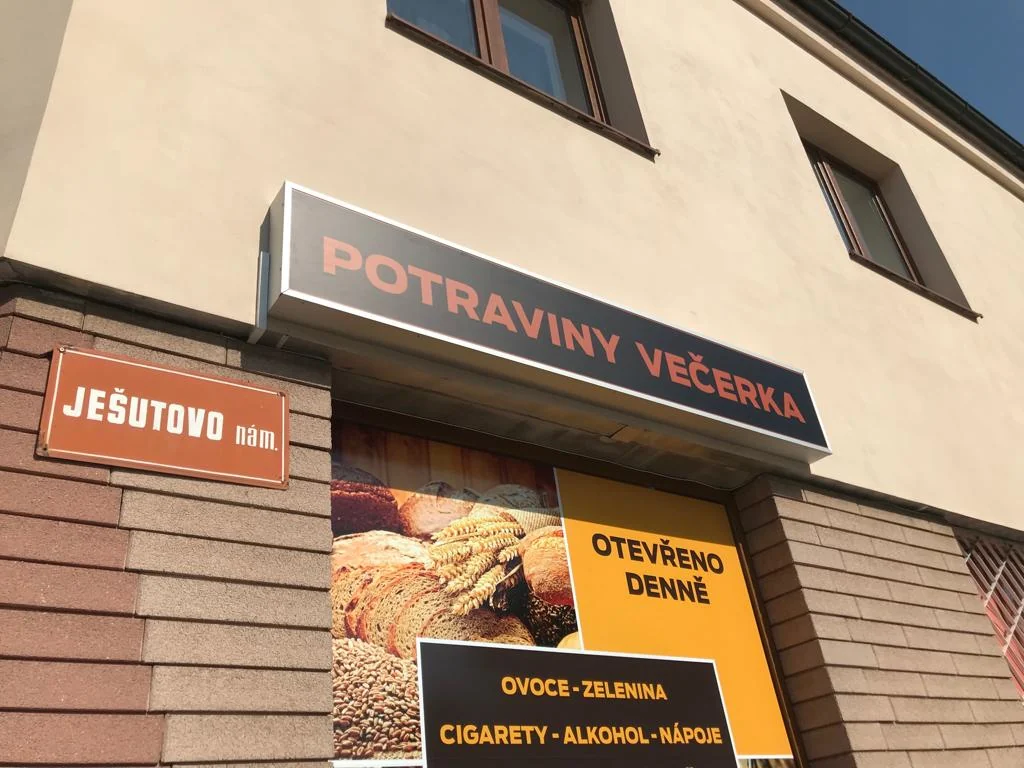 Detail horního označení Potraviny večerka a horní části polepené výlohy