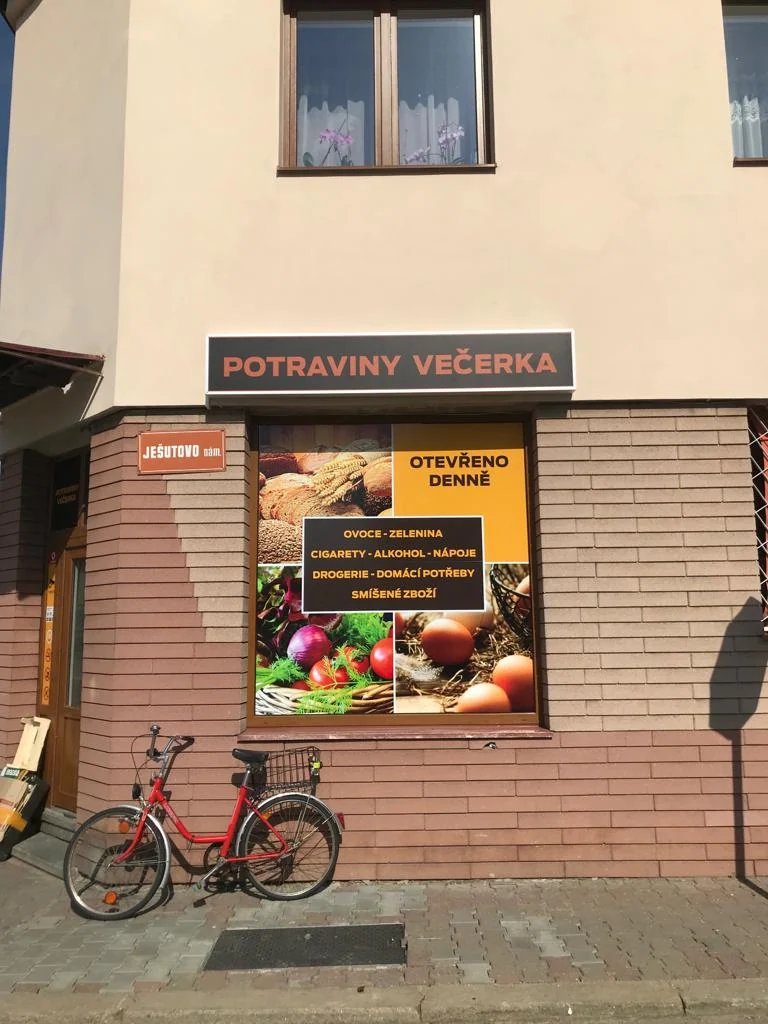 Velkoformátová grafika potravin ve výloze prodejny při pohledu z chodníku
